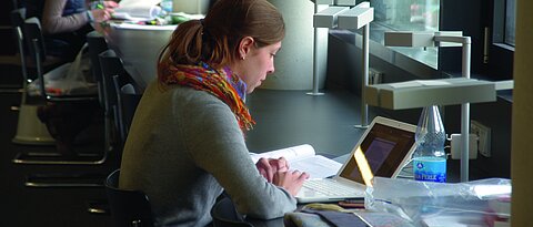 Picture of a studying women in the library. 