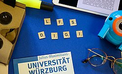 Auf dem Bild ist der Schriftzug LFS digi zu sehen. Dieser wurde auf einem blauen Hintergrund mit Spielsteinen gelegt. 