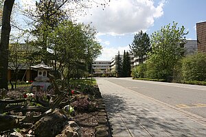 Blick auf Gebäude des Förderzentrums Sehen des Bildungszentrums für Blinde und Sehbehinderte Nürnberg - Profilschule Inklusion im Hintergrund. Garten im Vordergrund.